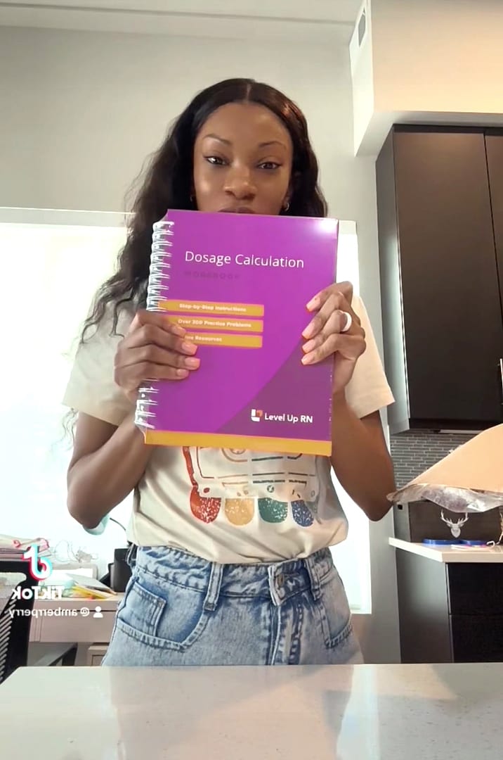 Dosage calculation workbook held up by amber